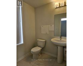 A white toilet and sink in a bathroom.