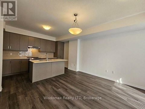 A kitchen with brown cabinets and a wooden floor.