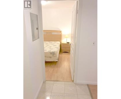 A bedroom with a bed, nightstand and lamp.
