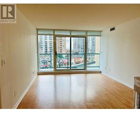 A room with a large window and wooden flooring.