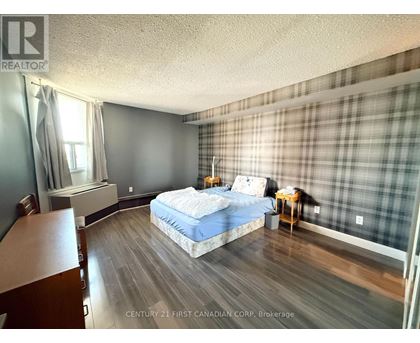 A bedroom with a bed, nightstand, and chair.