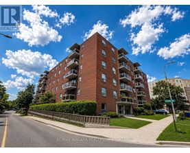 A tall red brick apartment building with balconies on the upper floors.