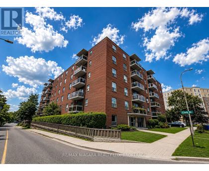 A tall red brick apartment building with balconies on the upper floors.