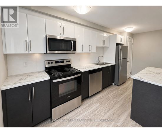 A kitchen with black cabinets and stainless steel appliances.