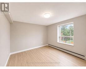 A room with a window and a wooden floor.