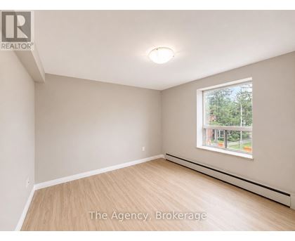 A room with a window and a wooden floor.