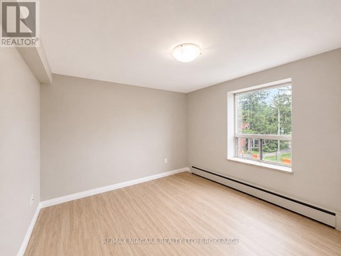A room with a window and a wooden floor.