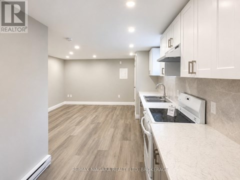 A kitchen with a white counter top and wooden floors.