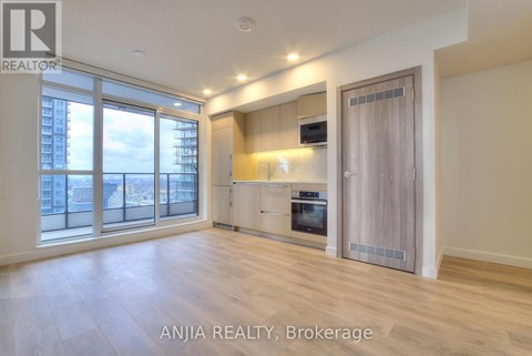 A spacious room with a kitchenette and a view of the city.
