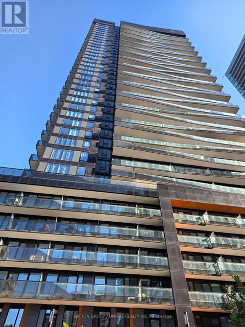 A tall building with many windows and balconies is shown in the image.