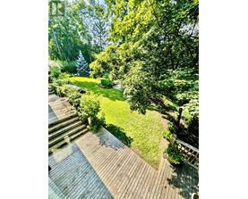 A deck leads down to a lush green lawn.