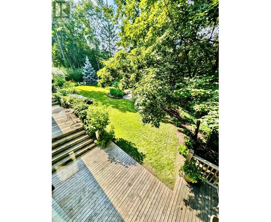 A deck leads down to a lush green lawn.