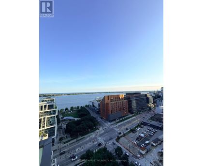 A view of a cityscape with a body of water in the background.