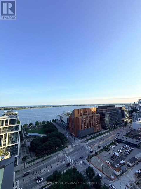 A view of a cityscape with a body of water in the background.