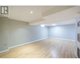 A spacious room with wooden flooring and white walls.