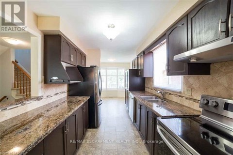 A kitchen with dark brown cabinets and granite countertops.