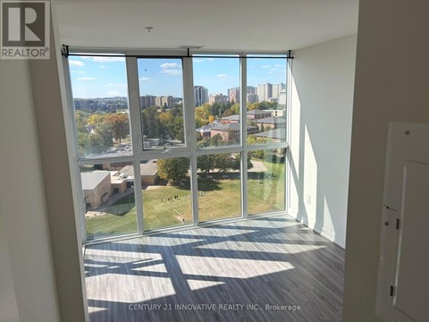 A room with a view of the city through large windows.