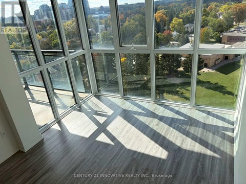 A room with a view of the city through large windows.