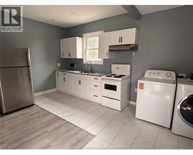 A kitchen with white appliances and cabinets.