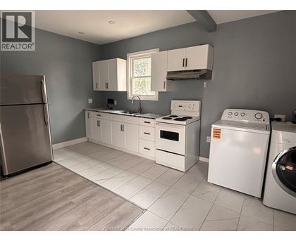 A kitchen with white appliances and cabinets.