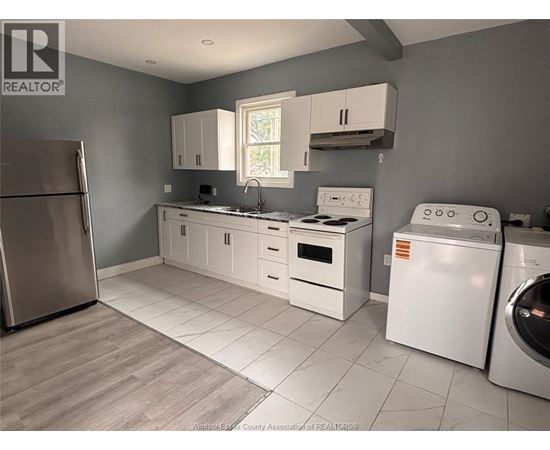 A kitchen with white appliances and cabinets.