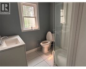A bathroom with a toilet, sink, and shower.