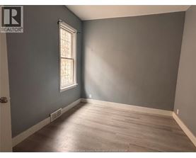 A room with a window and wooden flooring.