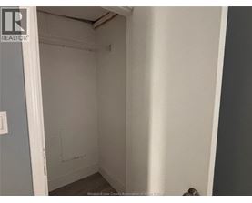 A small, empty room with a door on the left and a wall on the right.
