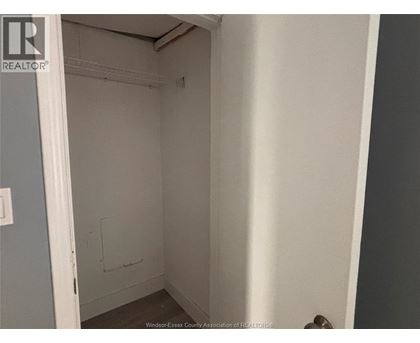 A small, empty room with a door on the left and a wall on the right.