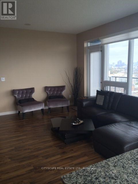 A living room with a black couch and two purple chairs.