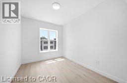 A room with a window and a white wall.