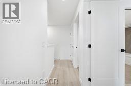 A hallway with a white door and a white wall.