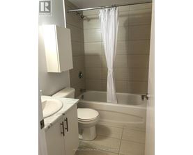 A white bathroom with a toilet, sink, and bathtub.