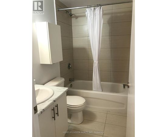 A white bathroom with a toilet, sink, and bathtub.