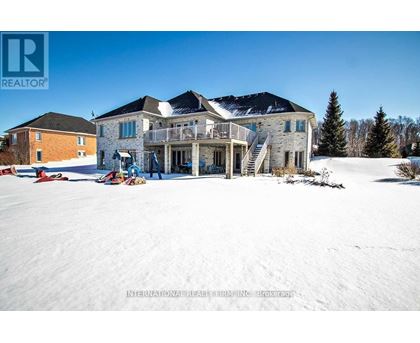 A large house with a balcony and a snow-covered ground.