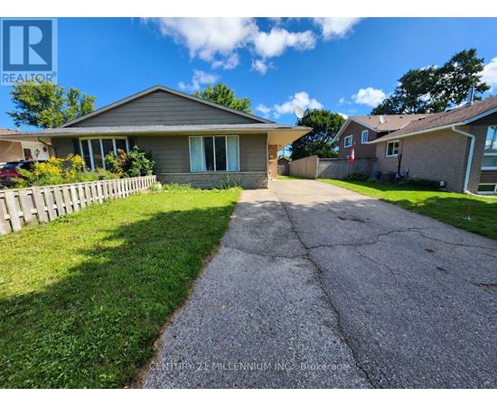 A house with a grey roof and a driveway in front of it.
