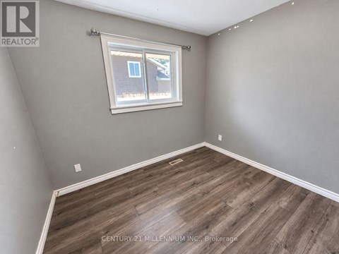 A room with a window and wooden flooring.