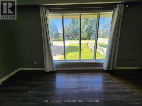 A room with a view of a street through the window.