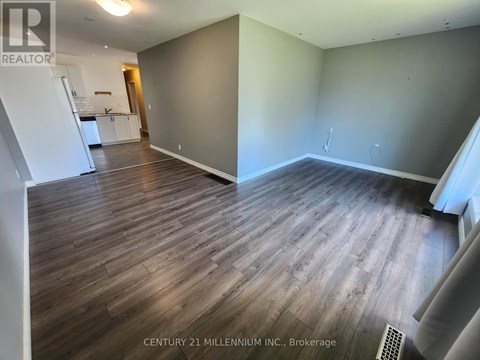 A room with wooden flooring and a white wall.