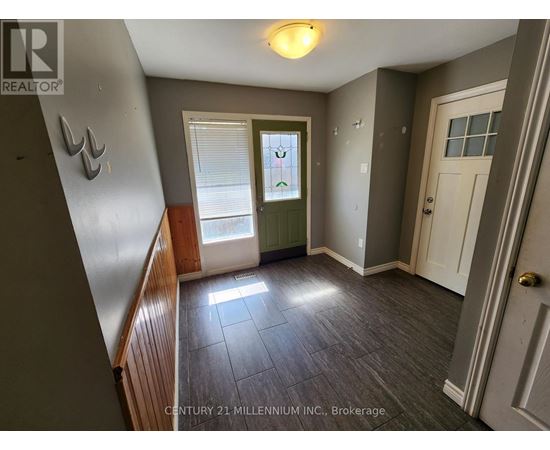 A room with a door, window, and a light on the ceiling.