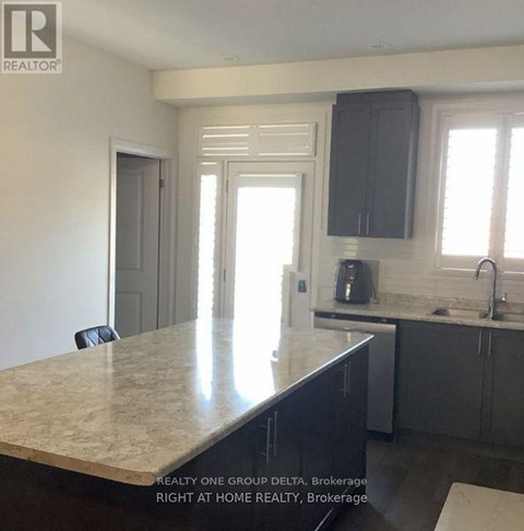 A kitchen with a marble countertop and a sink.