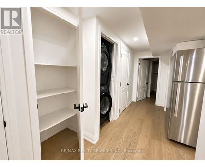 A white kitchen with a refrigerator and a washing machine.