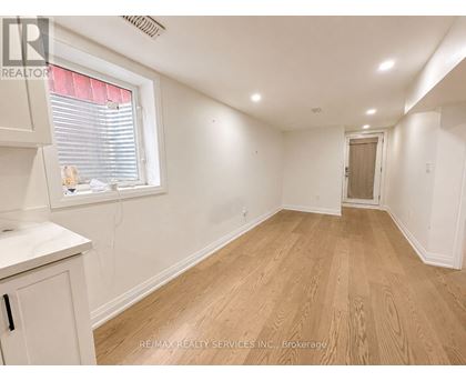 A room with wooden flooring and white walls.