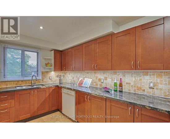 A kitchen with wooden cabinets and a tiled backsplash.