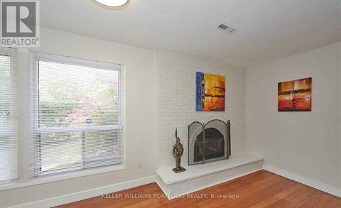 A living room with a fireplace and two paintings on the wall.