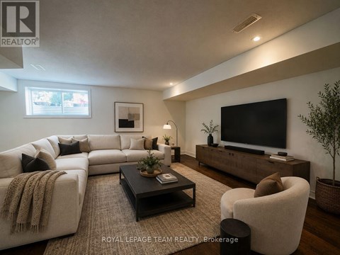 A living room with a large couch, a coffee table, and a flat-screen TV.