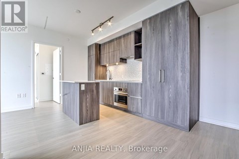 A modern kitchen with wooden cabinets and a stainless steel oven.