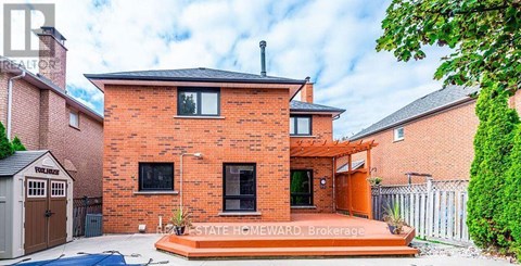 A red brick house with a white fence and a small garden.