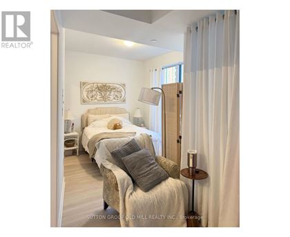 A bedroom with two beds and a nightstand with a lamp.