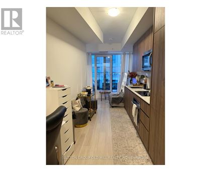 A well-lit kitchen with wooden cabinets and a large window.